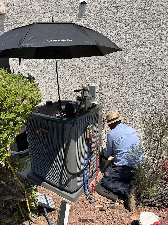 HVAC technician performing outdoor AC maintenance in Evergreen