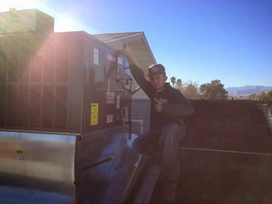 HVAC technician performing HVAC Inspection on a rooftop unit in Evergreen